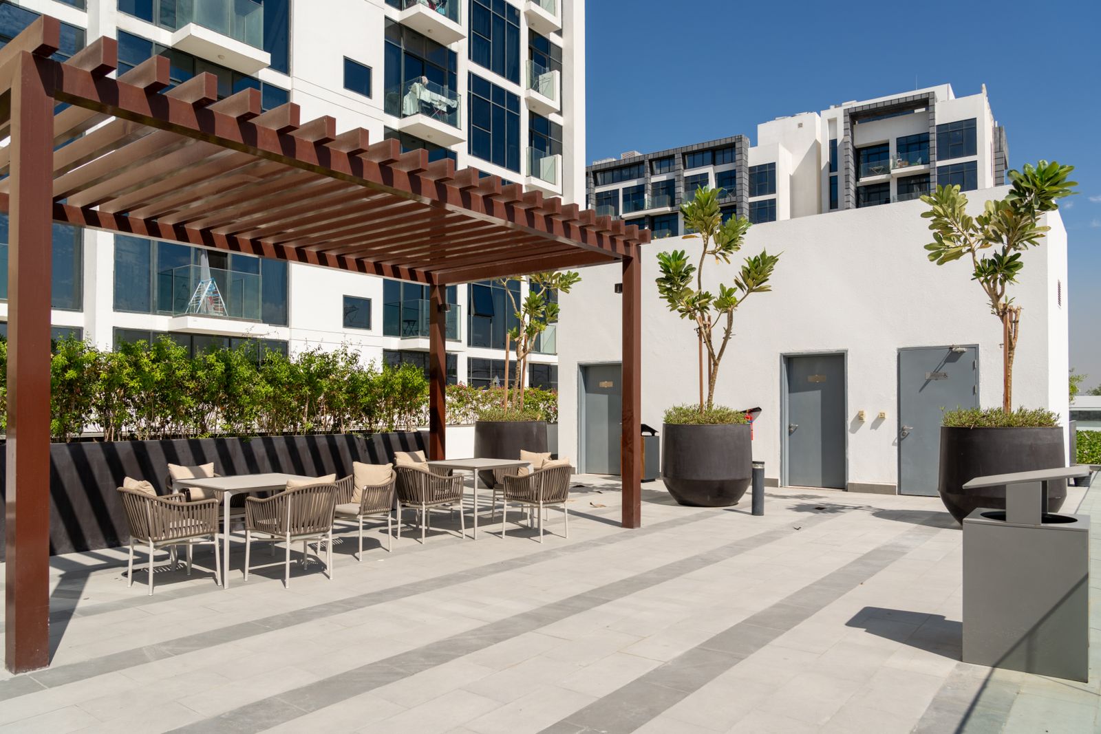 Terrasse aménagée sous une pergola à couverture fixe